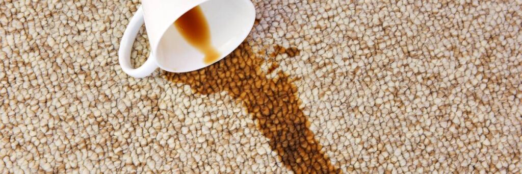 Kawa rozlana na jasnym dywanie. Obrazek w artykule Jak usunąć plamy z kawy? Praktyczne sposoby usuwania trudnych plam